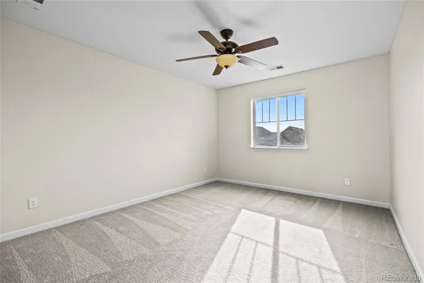 an empty room with a window and a ceiling fan