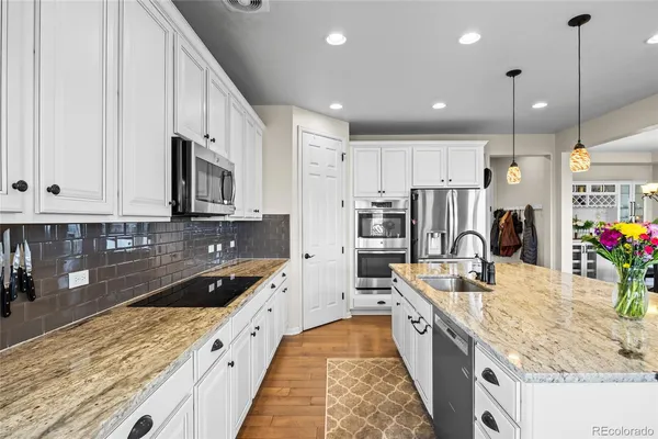 a large kitchen with stainless steel appliances kitchen island granite countertop a sink and cabinets