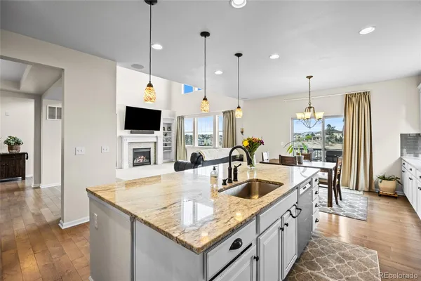 a kitchen with granite countertop a sink a counter top space and living room view