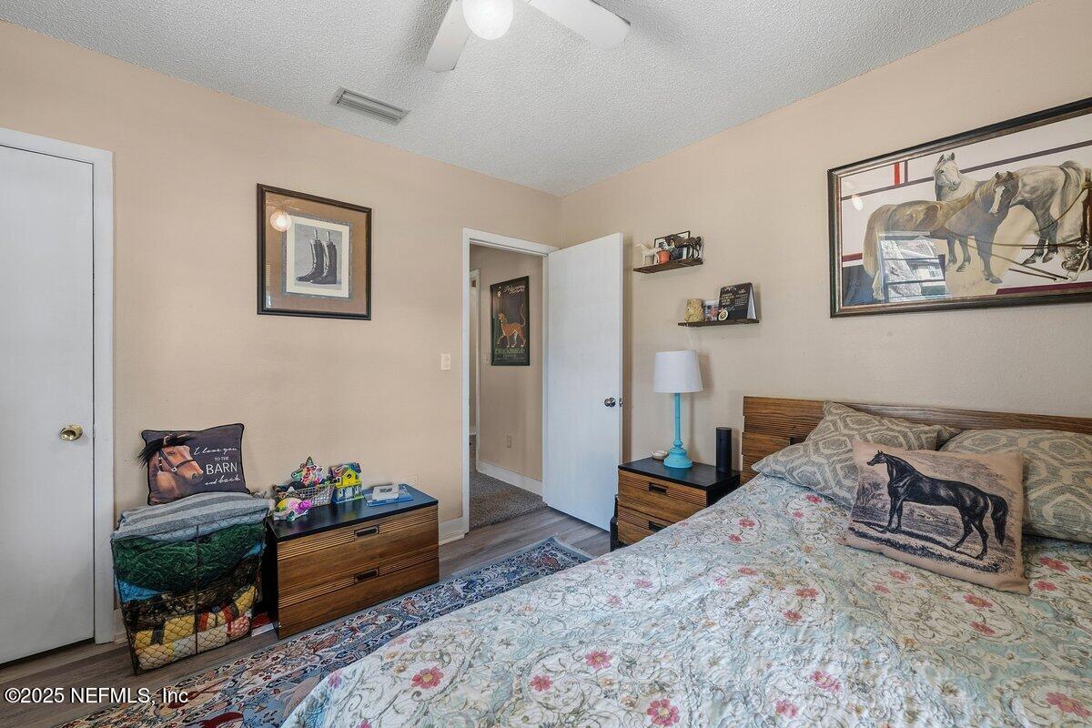 832 Lake Shore Terrace Interlachen, FL 32148 - Photo 18 of 42 a bedroom with a bed and wooden floor