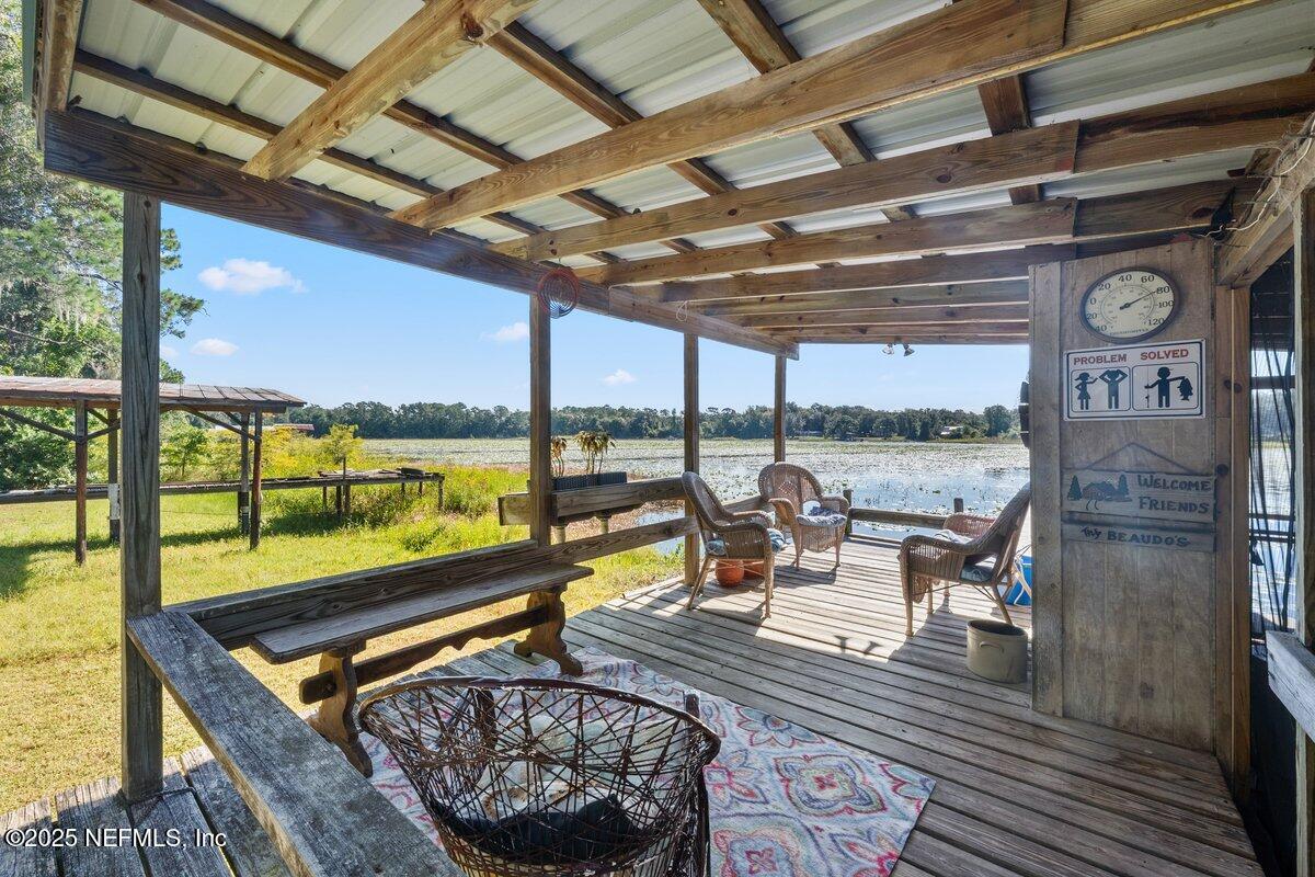 832 Lake Shore Terrace Interlachen, FL 32148 - Photo 27 of 42 a living room with patio furniture and a floor to ceiling window next to a yard