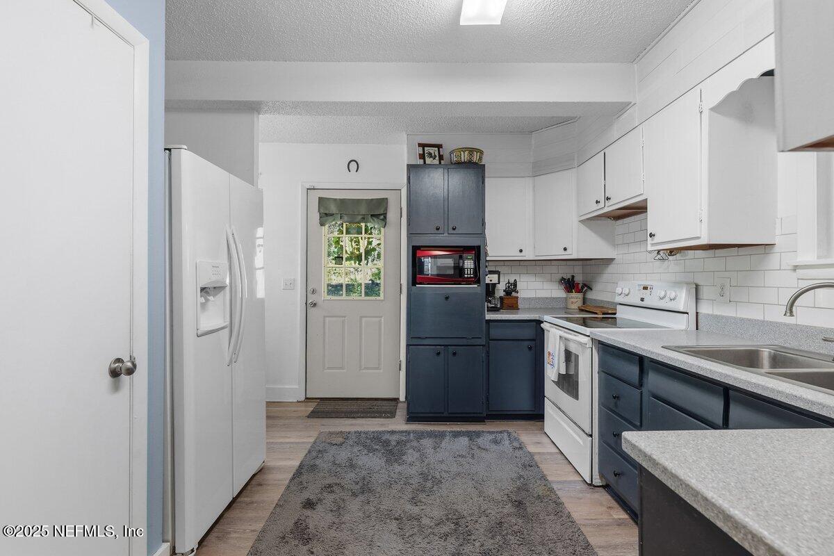 832 Lake Shore Terrace Interlachen, FL 32148 - Photo 5 of 42 a kitchen with stainless steel appliances granite countertop a refrigerator sink and cabinets