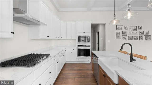 a view of a dining room and livingroom with furniture wooden floor a chandelier