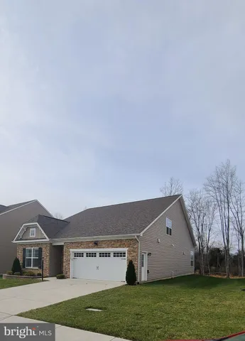a view of a hallway with wooden floor and a bathroom