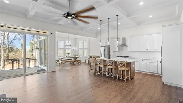 an open kitchen with wooden floor and stainless steel appliances