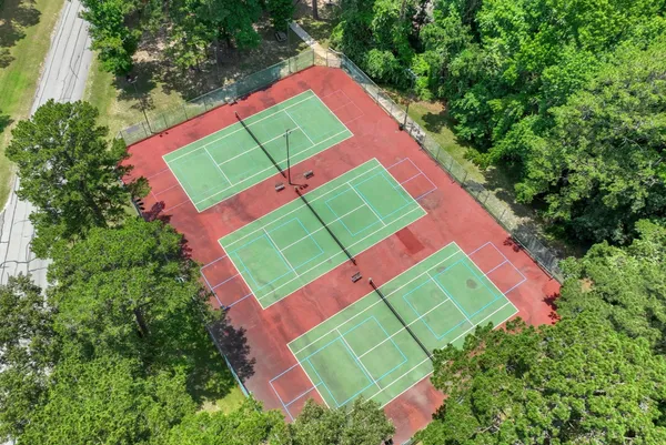 an aerial view of a tennis ground and a yard