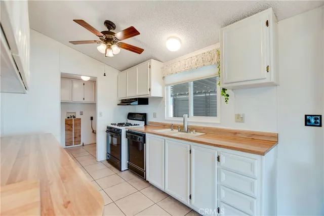 a kitchen with stainless steel appliances granite countertop a sink a stove a refrigerator with grey cabinets