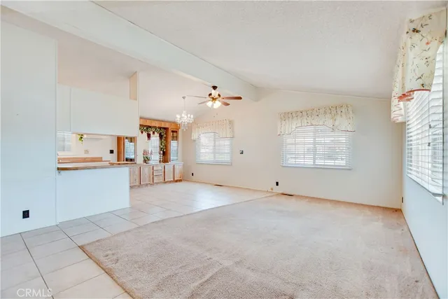 an empty room with windows and chandelier