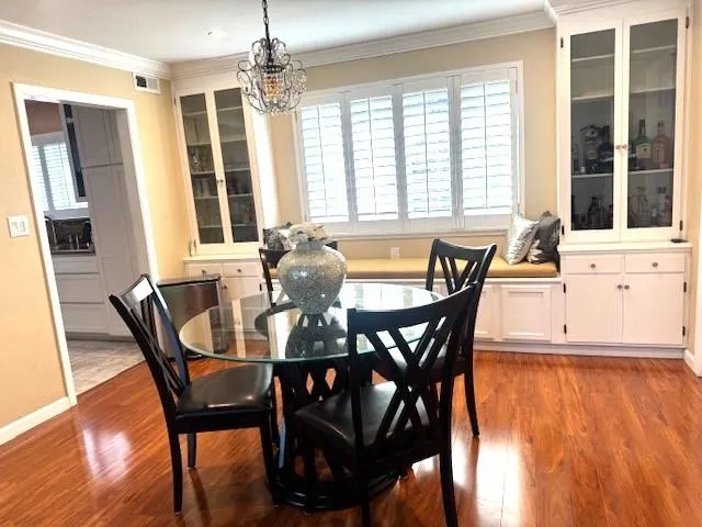 a dining room with furniture window wooden floor and a chandelier