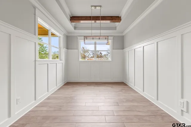 an empty room with a windows and chandelier