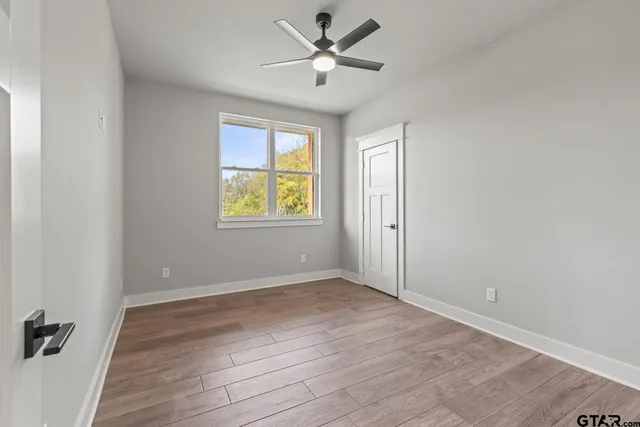 an empty room with a window and a ceiling fan