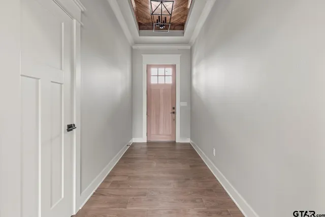 a view of a hallway with wooden floor and a window