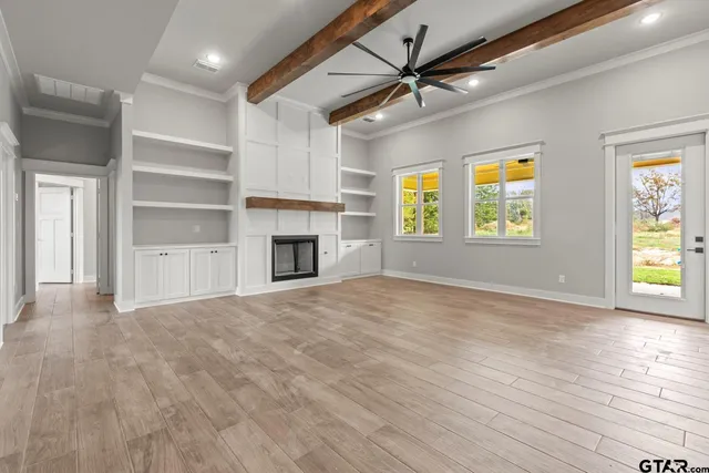 an empty room with windows and a fireplace