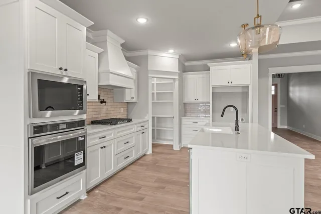 a kitchen with stainless steel appliances a stove sink and microwave