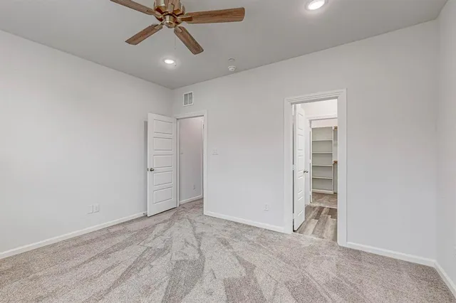 an empty room with closet and a ceiling fan