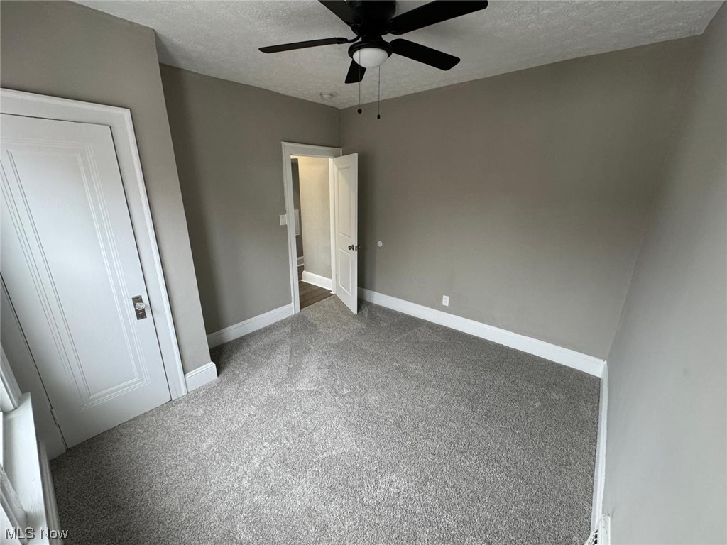 3333 Berea Road Cleveland, OH 44111 - Photo 27 of 34 Unfurnished bedroom with dark carpeting , a textured ceiling, and ceiling fan