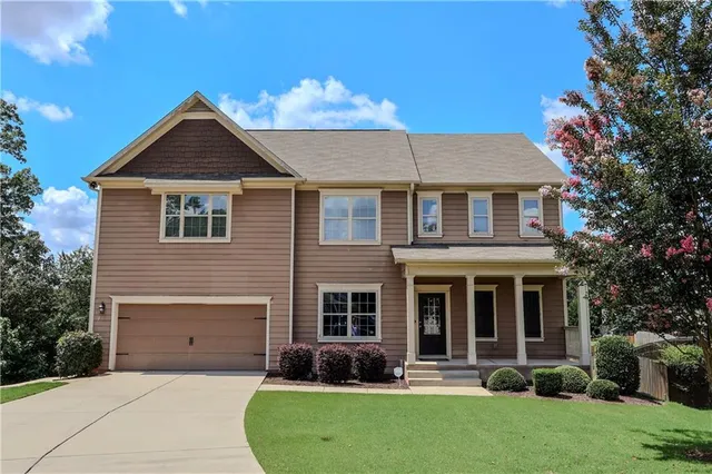a front view of a house with a yard and garage