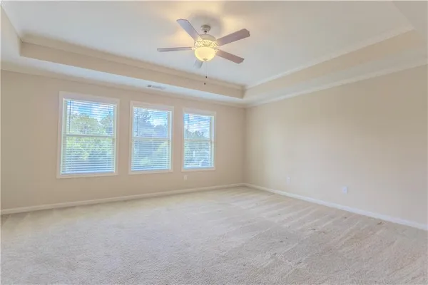 an empty room with ceiling fan and window