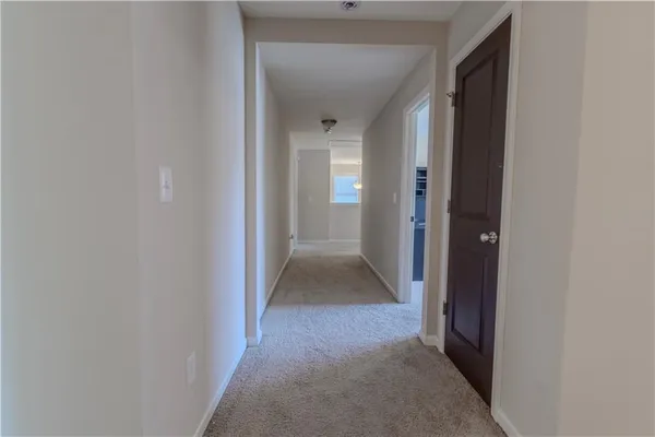 a view of a hallway with wooden floor and closet