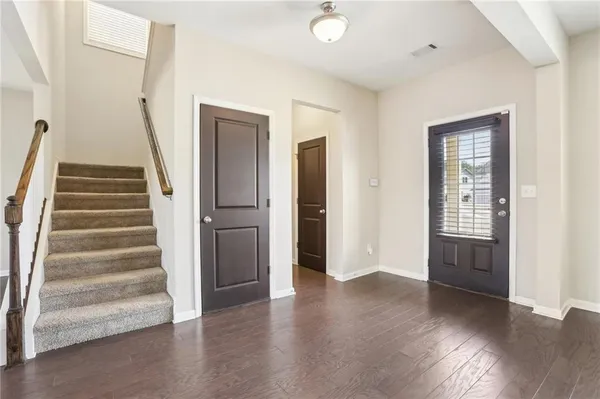a view of an entryway with wooden floor and stairs