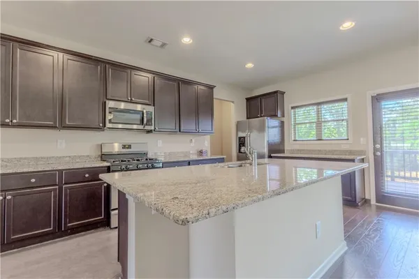 a kitchen with stainless steel appliances granite countertop a sink stove and microwave