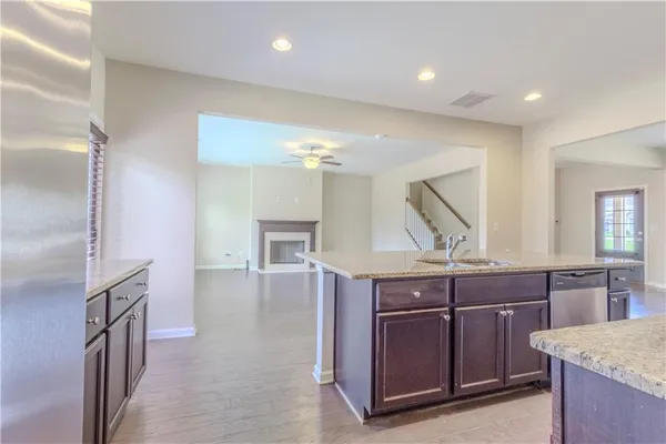 a kitchen with kitchen island granite countertop a sink and refrigerator