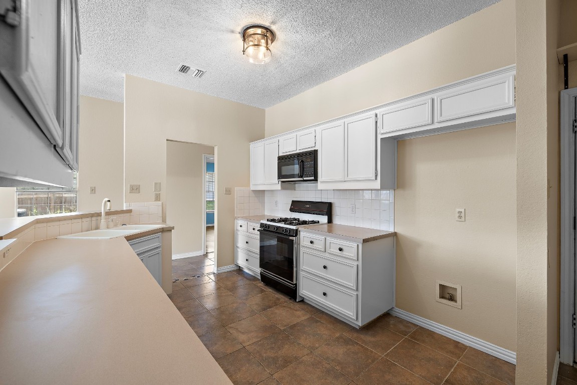 1815 Rusty Nail Loop Round Rock, TX 78681 - Photo 11 of 27 a large kitchen with cabinets and stainless steel appliances