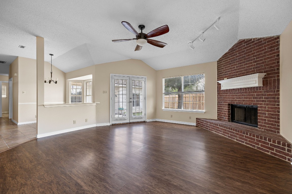 1815 Rusty Nail Loop Round Rock, TX 78681 - Photo 4 of 27 a view of an empty room with wooden floor and a fireplace
