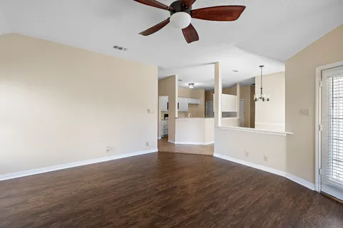 a view of a kitchen with wooden floor and a ceiling fan