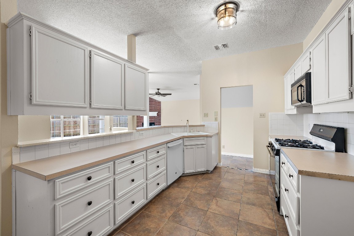 1815 Rusty Nail Loop Round Rock, TX 78681 - Photo 10 of 27 a kitchen with granite countertop a sink white cabinets and white appliances