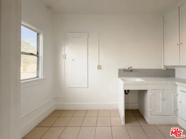 a view of an empty room with window and cabinet