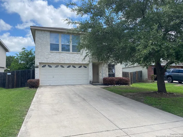 front view of a house with a yard and a trees
