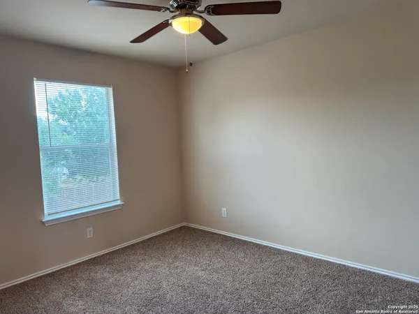 en view of an empty room with a chandelier fan