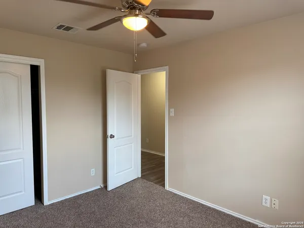 an empty room with a window and a fan