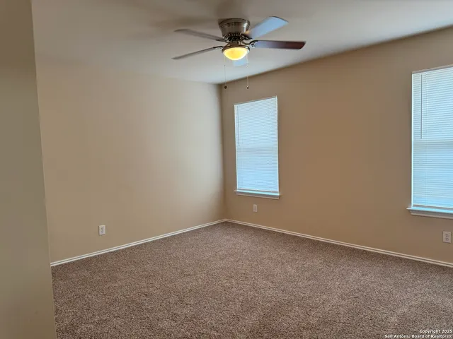 an empty room with fan and entrance