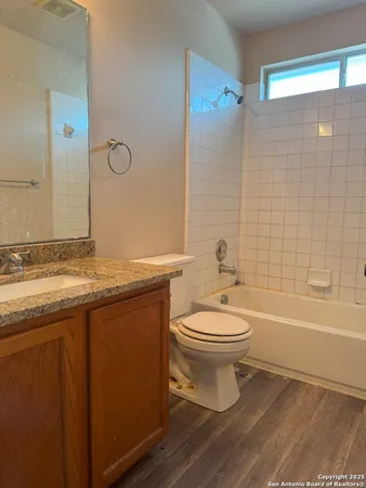 an empty room with a ceiling fan and windows