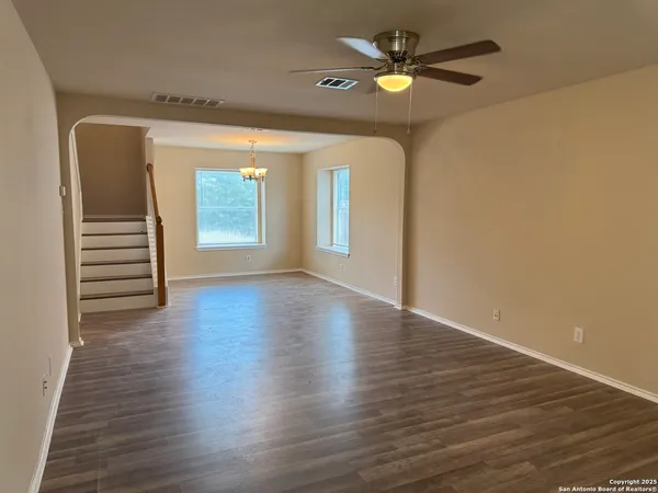a view of an empty room with a window and wooden floor