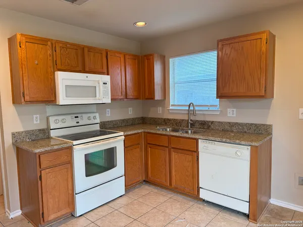 a kitchen with granite countertop cabinets sink and stainless steel appliances