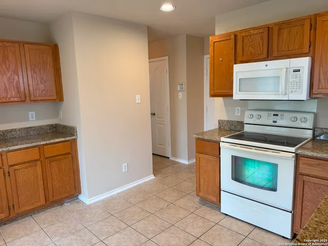a kitchen with granite countertop cabinets stainless steel appliances and a counter space