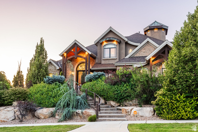 694 West Cephus Road Draper, UT 84020 - Photo 127 of 148 Stately residence featuring a stone and stucco exterior, prominent arched entryway with wrought iron details, and a distinctive turret