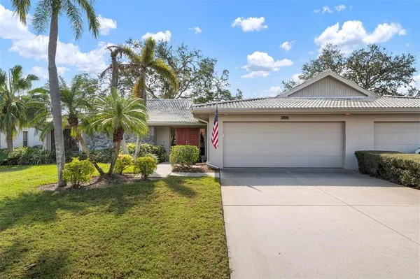 a view of a house with a yard and palm trees