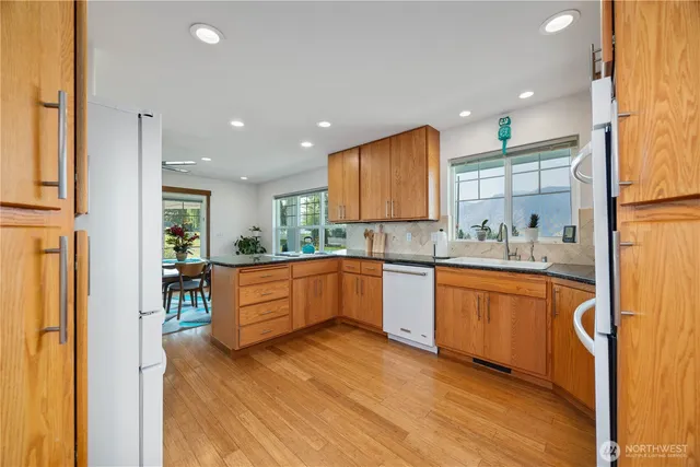 a large kitchen with stainless steel appliances granite countertop a lot of counter space and a sink