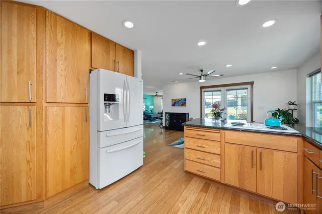 a kitchen with stainless steel appliances a refrigerator and wooden floor