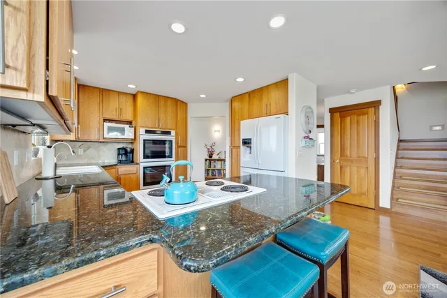 a kitchen with stainless steel appliances granite countertop a granite counter tops and a view of living room