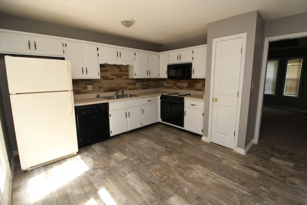 a kitchen with stainless steel appliances granite countertop a refrigerator stove a sink and dishwasher
