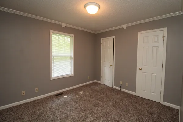 an empty room with windows and closet