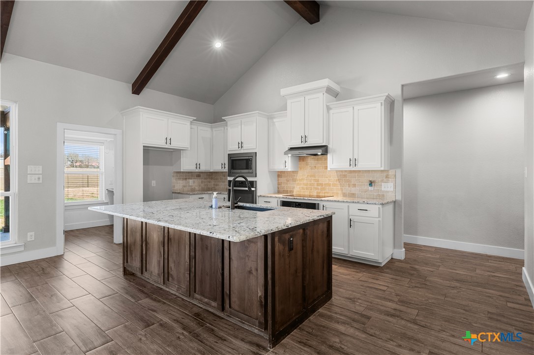 15020 Old Troy Road Troy, TX 76579 - Photo 16 of 48 a kitchen with a sink a stove a refrigerator and white cabinets