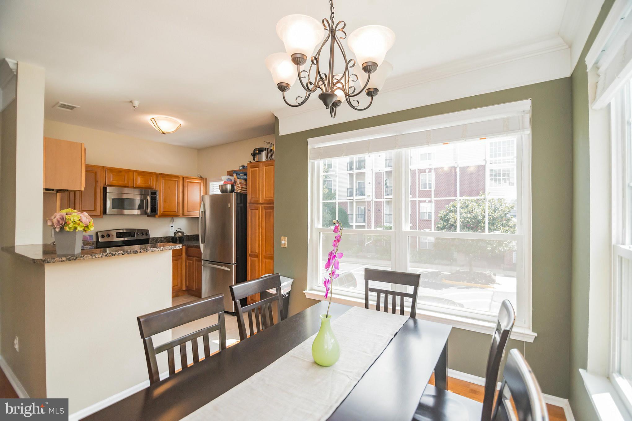 1600 Spring Gate Dr., Unit 2215 McLean, VA 22102 - Photo 13 of 30 a dining room with furniture a chandelier and wooden floor