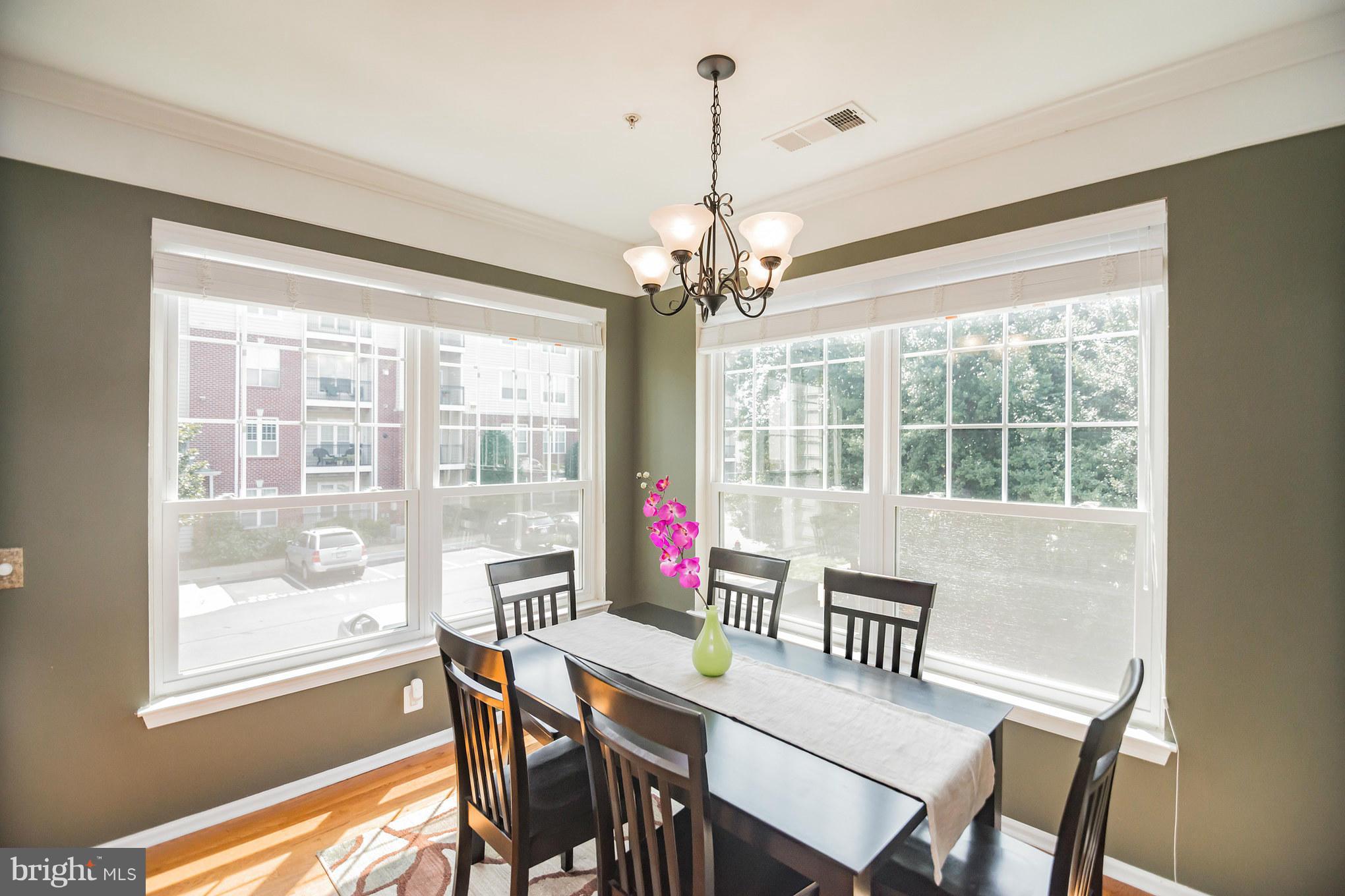 1600 Spring Gate Dr., Unit 2215 McLean, VA 22102 - Photo 14 of 30 a dining room with wooden floor a chandelier a wooden table and chairs