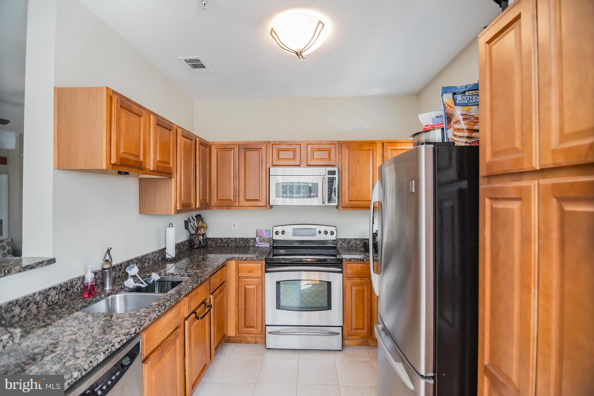 1600 Spring Gate Dr., Unit 2215 McLean, VA 22102 - Photo 15 of 30 a kitchen with stainless steel appliances granite countertop a refrigerator and a stove